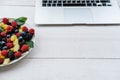 Workspace with laptop and healthy berries in rainbow colours, pi Royalty Free Stock Photo