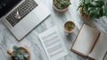 Workspace with Laptop, Plants, Coffee, and Notes on Marbled Surface Royalty Free Stock Photo