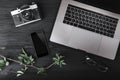 Workspace with notebook or laptop, smartphone, photo camera and eyeglasses on wood texture background. Top view, flat lay style Royalty Free Stock Photo