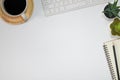 Workspace office with a white desk. Top view from above with keyboard, notebook and pencil with a white cup coffee on the wooden p Royalty Free Stock Photo