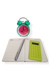 Workspace setup with alarm clock, open notebook, pen, and calculator, representing planning, time awareness, and calculations. Royalty Free Stock Photo
