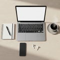 A workspace setup on a light wooden desk includes an open lapt Royalty Free Stock Photo