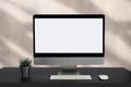 Workspace with simulated blank white screen computers and office equipment on a wooden table