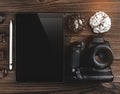 Workspace with tablet, professional camera and chocolate biscuits on wooden table. View from above Royalty Free Stock Photo