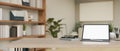 Workspace with tablet mockup on a light wood tabletop in minimal working room