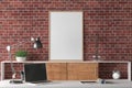 Workspace with vertical poster mock up on the desk. Desk with drawers in interior of the studio or at home with red brick wall. Royalty Free Stock Photo