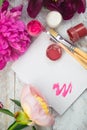 Workspace. Watercolor, paintbrush and pink peonies isolated on white background. Overhead view.