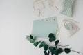 Workspace. Wedding invitation card and eucalyptus leaves on white background