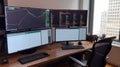 A workstation with multiple monitors displaying charts and data near window Royalty Free Stock Photo