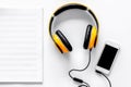 Worktable of composer today. Headphones, phone, music notes on white background top view Royalty Free Stock Photo