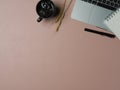 Worktable with copy space, laptop, coffee mug and stationery on pink table