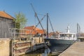 Yacht with woman passing sluice in historic Dutch village Workum