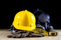 Workwear, helmet, gloves and glasses on a wooden working table.