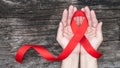 World aids day and national HIV/AIDS and ageing awareness month with red ribbon on woman hand support bow isolated Royalty Free Stock Photo