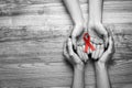 World AIDS disease day. Women holding red awareness ribbon on wooden background, top view with space for text Royalty Free Stock Photo