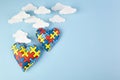 World autism awareness day. Awareness healthcare concept. Puzzle hearts on blue sky.