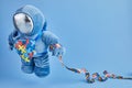 World Autism awareness day background. Blue plush astronaut toy with puzzle heart, autism symbol, on blue background