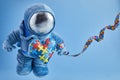 World Autism awareness day background. Blue plush astronaut toy with puzzle heart, autism symbol, on blue background