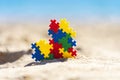 World autism awareness day background. Multicolored puzzle heart on the beach in sunny day Royalty Free Stock Photo