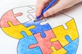 World Autism Awareness day. Children`s hand draws heart from multi-colored puzzles. Mental health care concept