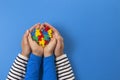 World autism awareness day concept. Adult and child hands holding puzzle heart on light blue background