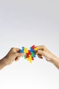 World autism awareness day concept. Children hands holding colorful puzzle heart on white background Royalty Free Stock Photo