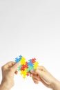 World autism awareness day concept. Children hands holding colorful puzzle heart on white background Royalty Free Stock Photo