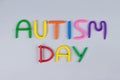 World Autism Awareness Day concept - multicolored letters made of play-doh or other sensory playfoam on light gray