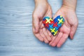 World Autism Awareness day, puzzle or jigsaw pattern on heart with autistic child`s hands
