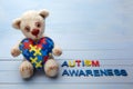 World Autism Awareness day, mental health care concept with teddy bear holding puzzle or jigsaw pattern on heart
