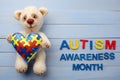 World Autism Awareness month, mental health care concept with teddy bear holding puzzle or jigsaw pattern on heart Royalty Free Stock Photo