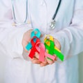 World cancer day, February 4. Doctor hold colorful ribbons, blue, yellow, red, green, white, pink and grey for supporting people Royalty Free Stock Photo