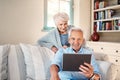 The world is always changing. a senior couple using a digital tablet together in their living room at home. Royalty Free Stock Photo