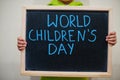 World children`s day. Boy hold chalkboard with blue inscription