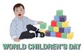 World Children`s Day card. happy dark-haired child in a light blue shirt with white hearts playing with cubes