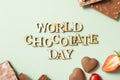 World chocolate day text with chocolate flat lay, top view on pastel green background