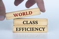 World class efficiency text on wooden blocks. Business culture and Operational excellence concept