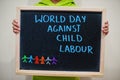 World day against child labour. Boy hold chalkboard with blue inscription