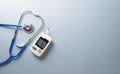 World Diabetes day concept ,14 November. Top view of blood glucose meter sets and stethoscope on pastel blue background Royalty Free Stock Photo