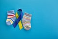 World Down syndrome day background. Down syndrome awareness concept. Socks and ribbon on blue background