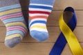 World Down syndrome day background. Down syndrome awareness concept. Socks and ribbon on wooden background