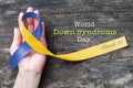 World down syndrome day WDSD March 21 Blue yellow awareness ribbon on helping hand for raising support on patient