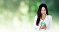 Asian woman hands holding earth globe against blurred green forest with rain sunrise