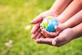 World environment day concept. A mother`s hand embrace her little daughter`s hands. Child hand`s who is holding carry the worl Royalty Free Stock Photo
