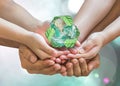 World environment day and ecology concept with family`s hands saving green planet with recycle sign. Royalty Free Stock Photo