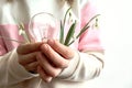 World Environment Day: a light bulb and a bouquet of snowdrops in the hands of a child, close-up, space for text Royalty Free Stock Photo