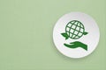 World environment day, responsible consumption Social responsibility core value concept. Green earth icon over hand on white