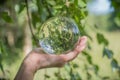 World environmental concept. Crystal globe in human hand on beautiful green and blue bokeh Royalty Free Stock Photo