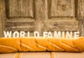 World famine word on baguette with wood background