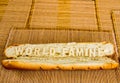 World famine word on baguette with wood background
